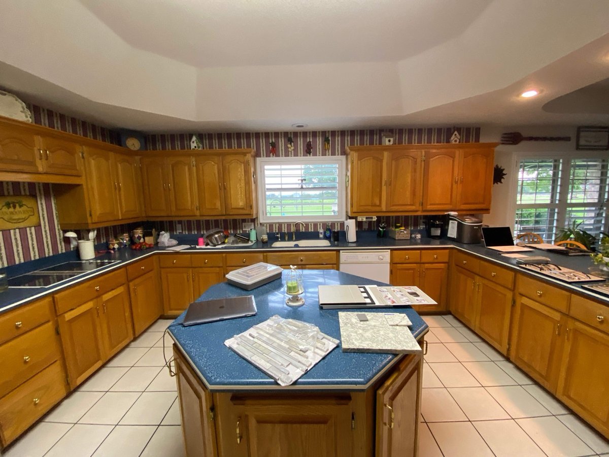 Original dated kitchen with oak cabinets, blue countertops and striped wallpaper