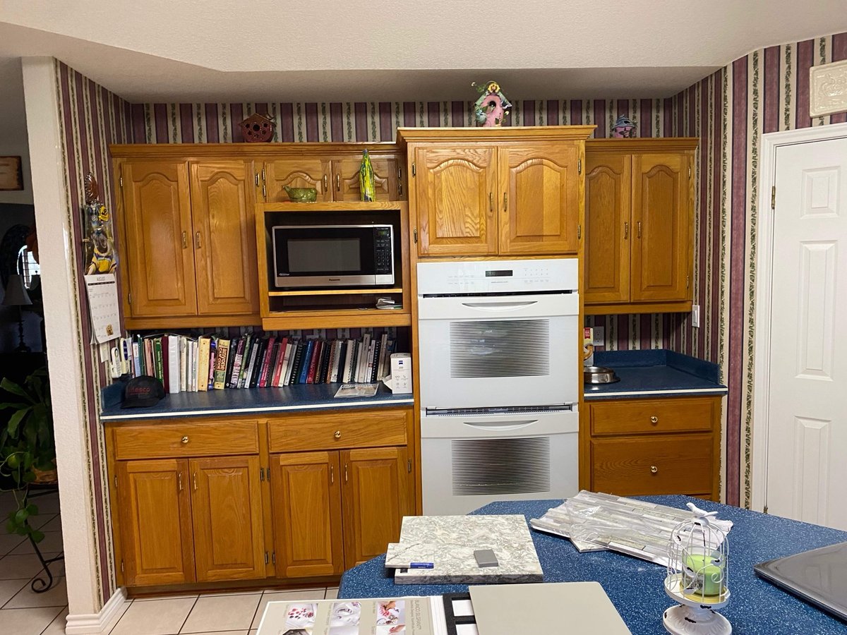 Old oak cabinet wall with microwave, white double oven and bookshelf nook