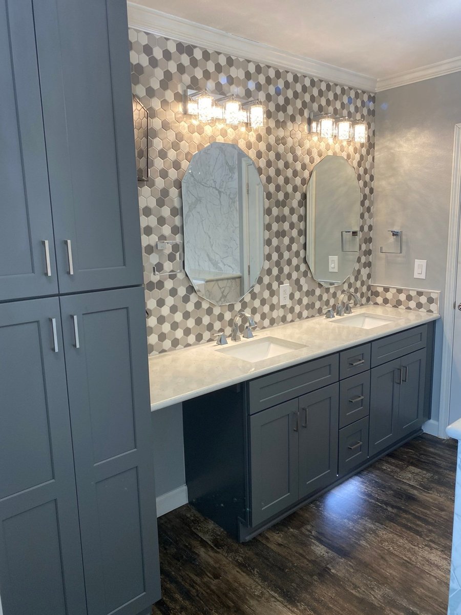 Gray double vanity with oval mirrors and hexagon mosaic accent wall under sconces