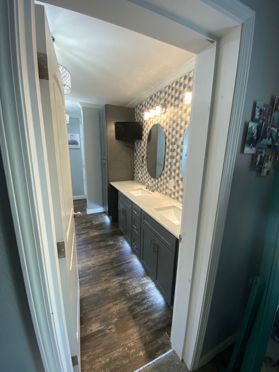 Doorway view into gray double vanity bath with hexagon mosaic accent wall