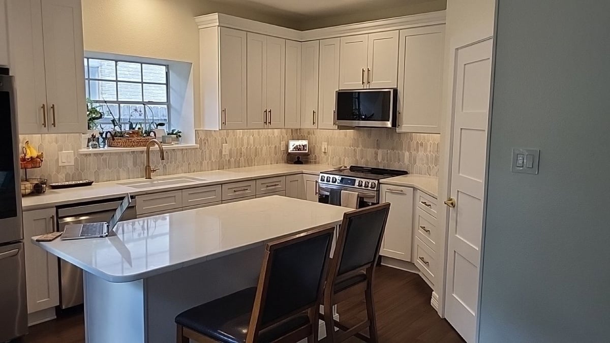 White shaker kitchen with quartz counters, island, and picket backsplash
