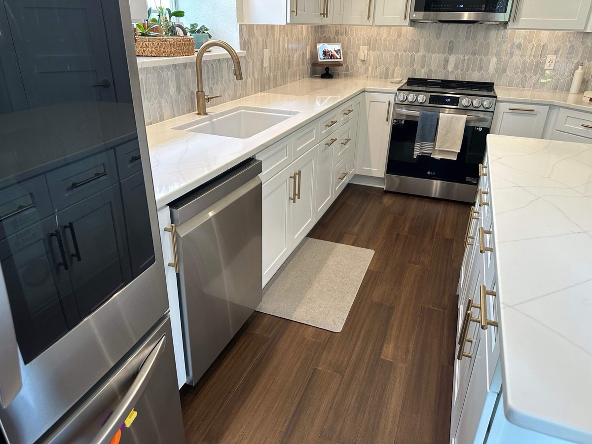White kitchen island with veined quartz top and leather counter stools