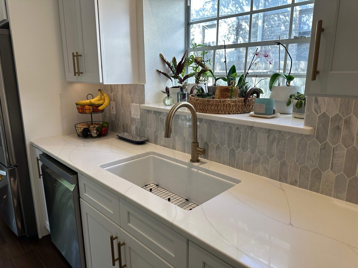 White shaker kitchen with stainless fridge, island, and picket backsplash