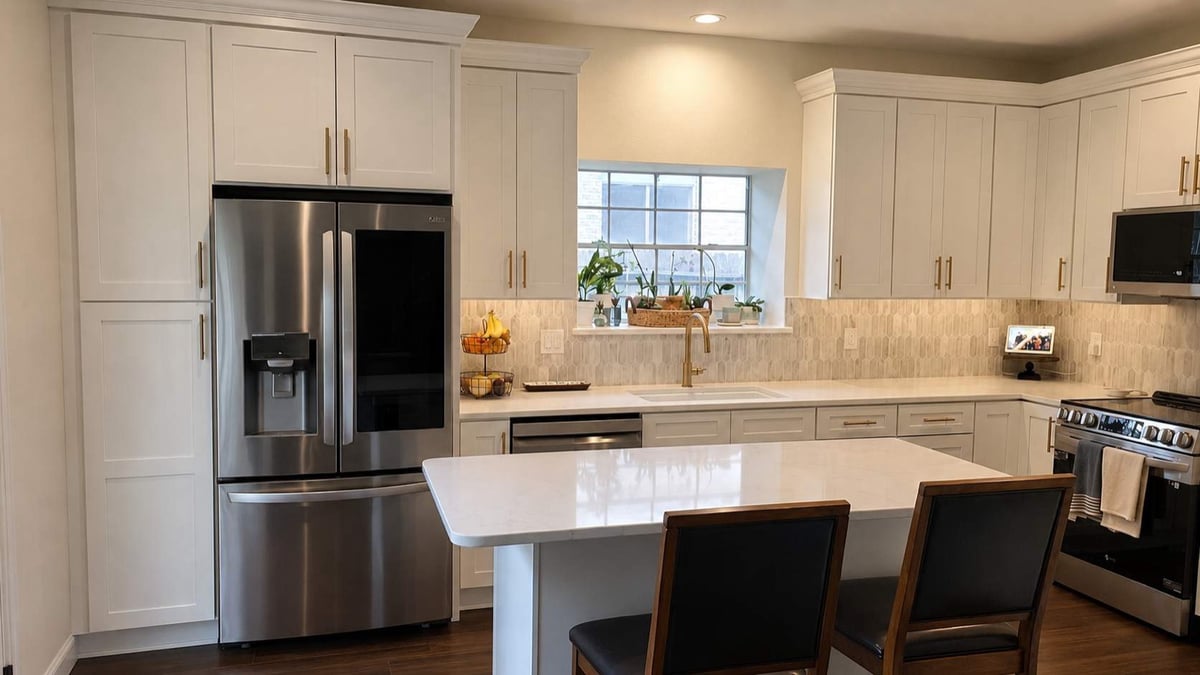 Remodeled white shaker kitchen with quartz island, gold faucet, and stainless steel appliances