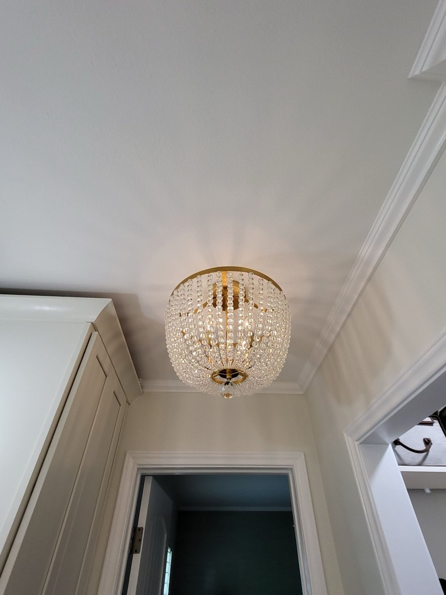 Brushed gold shower head and valve trim on blue-gray subway tile