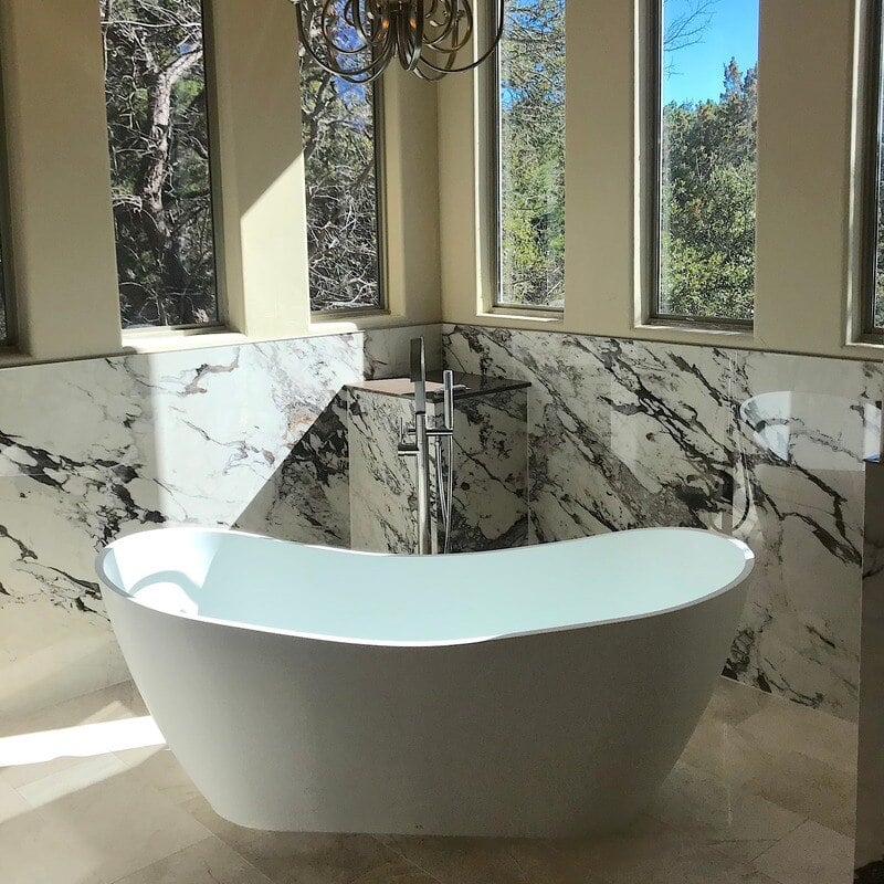 Standalone bathtub with marble tile floors