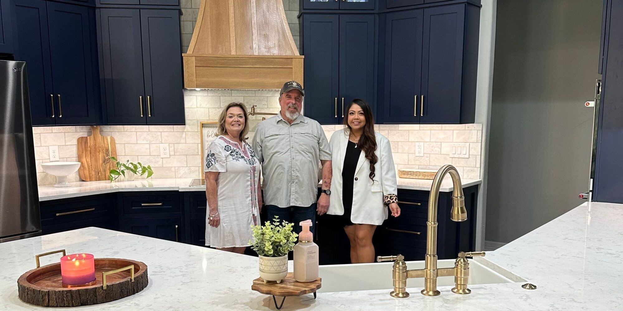 Family standing in front of their remodeled kitchen in spring branch tx with blue cabinets and white countertops and backsplash