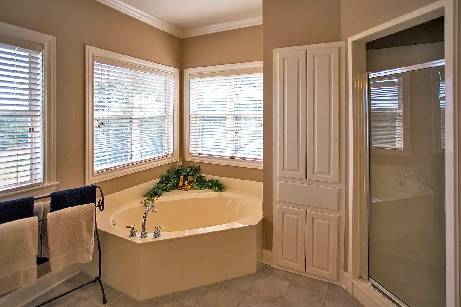 outdated bathroom with large tub and glass door shower